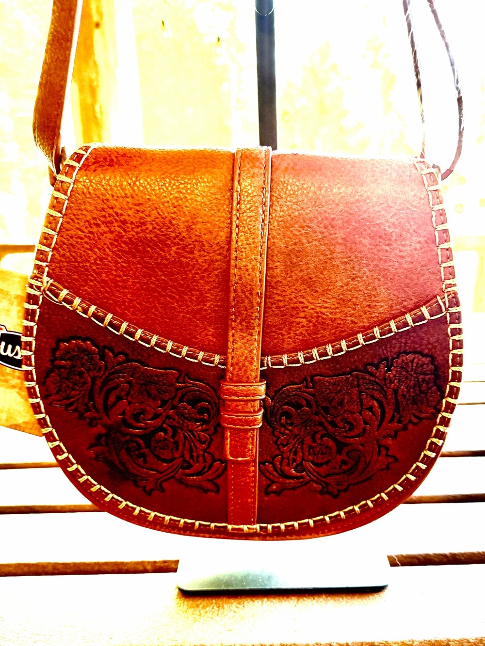Justin Brown Leather Crossbody Bag with Embossed Floral Detail.